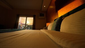 A hotel room with a bed, a view of the sunset through a window, and a balcony. - Hotel 360 By D'Polo Dharamshala (Dharamshala)