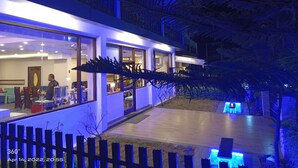 A modern building with large windows and a visible interior. - Hotel 360 By D'Polo Dharamshala (Dharamshala)