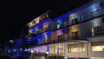 A multi-story boutique hotel with a covered entrance and balconies on each floor.