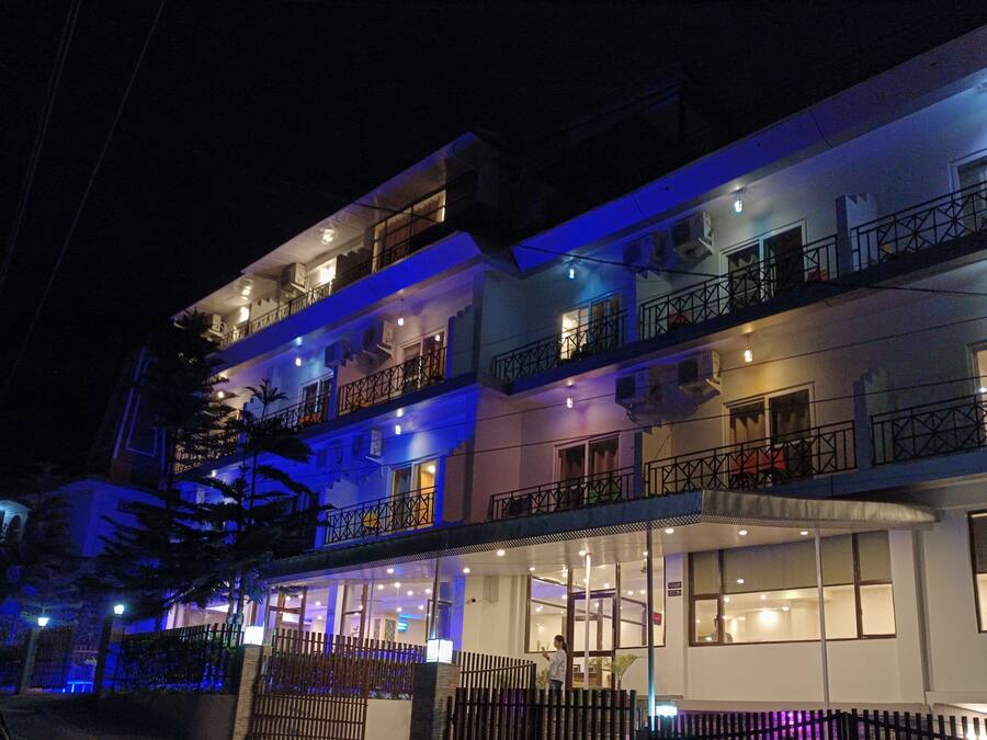 Un hotel boutique de varios pisos con entrada cubierta y balcones en cada planta.