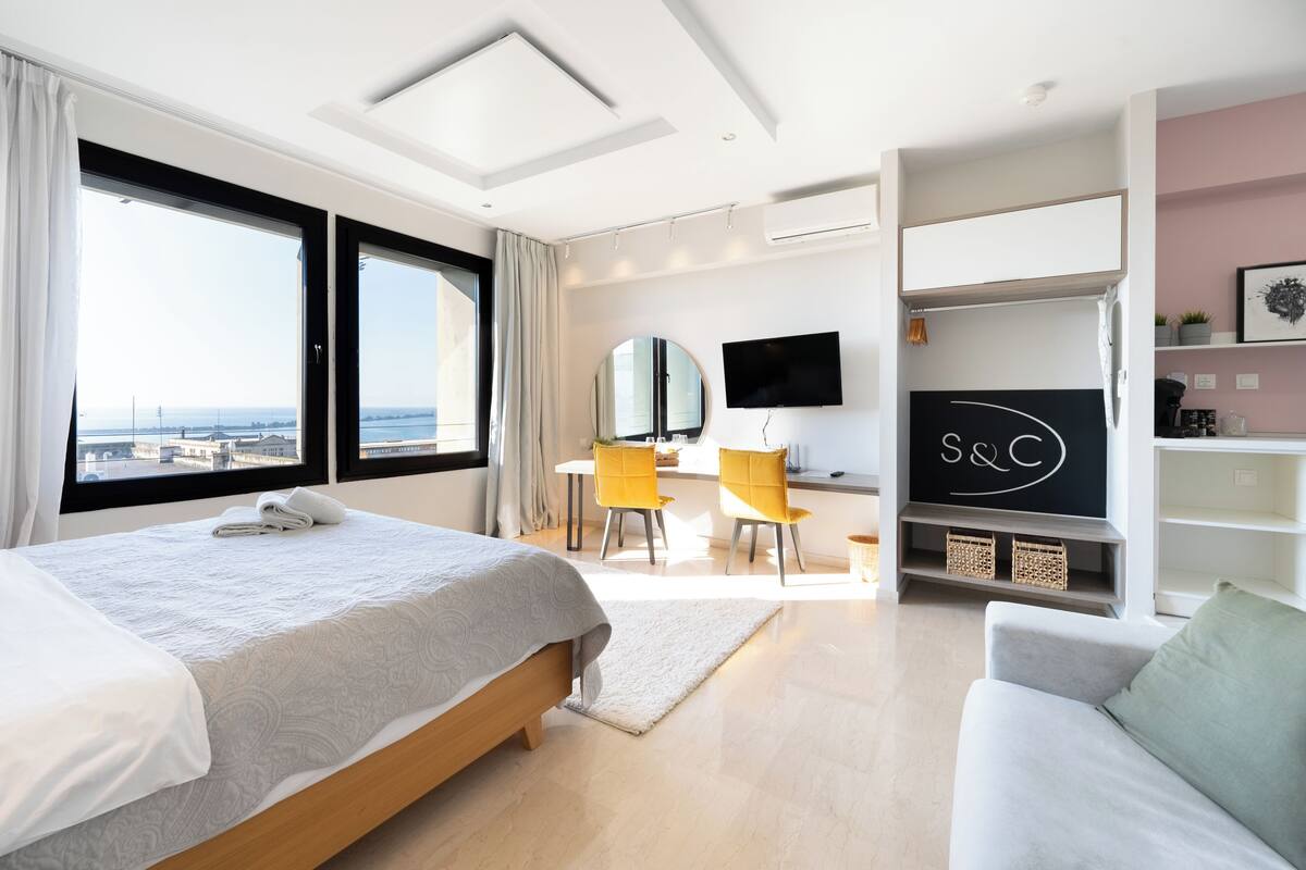 Een moderne hotelkamer met een groot bed, een bureau, een televisie en uitzicht op de stad.