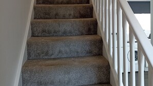 A staircase with carpeted steps and white railings.
