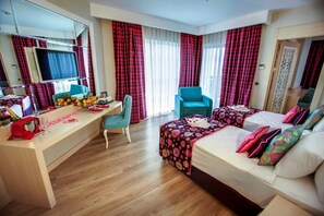 A hotel room with a bed, a desk, a chair, and a large mirror. - Azura Deluxe Resort & Spa Avsallar (Alanya)