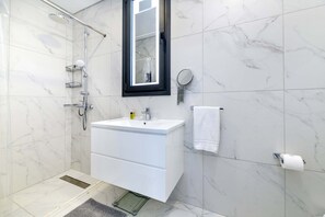 Regadera, secadora de cabello, shampoo, papel de baño 