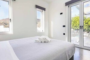 A bedroom with a bed, a window, and a view of the outdoors. - Villa Paradiso Tria - Two Bedroom Villa, Sleeps 4 (Malevizi)