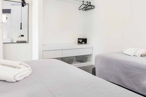 A hotel room with a bed, a bedside table, a mirror, a hanging light, a towel, and a small shelf with a box. - Villa Paradiso Tria - Two Bedroom Villa, Sleeps 4 (Malevizi)