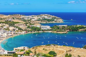 A coastal town with buildings along the shoreline, boats in the water, and a clear view of the sea. - Villa Paradiso Tria - Two Bedroom Villa, Sleeps 4 (Malevizi)
