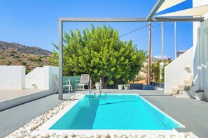 A swimming pool with a clear blue water, surrounded by white pebbles, and a tree in the background. - Villa Paradiso Tria - Two Bedroom Villa, Sleeps 4 (Malevizi)