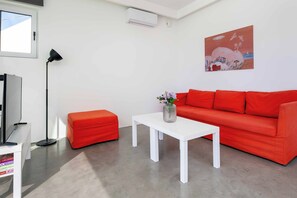 A modern living room with a red sofa, a white coffee table, and a painting on the wall. - Villa Paradiso Tria - Two Bedroom Villa, Sleeps 4 (Malevizi)