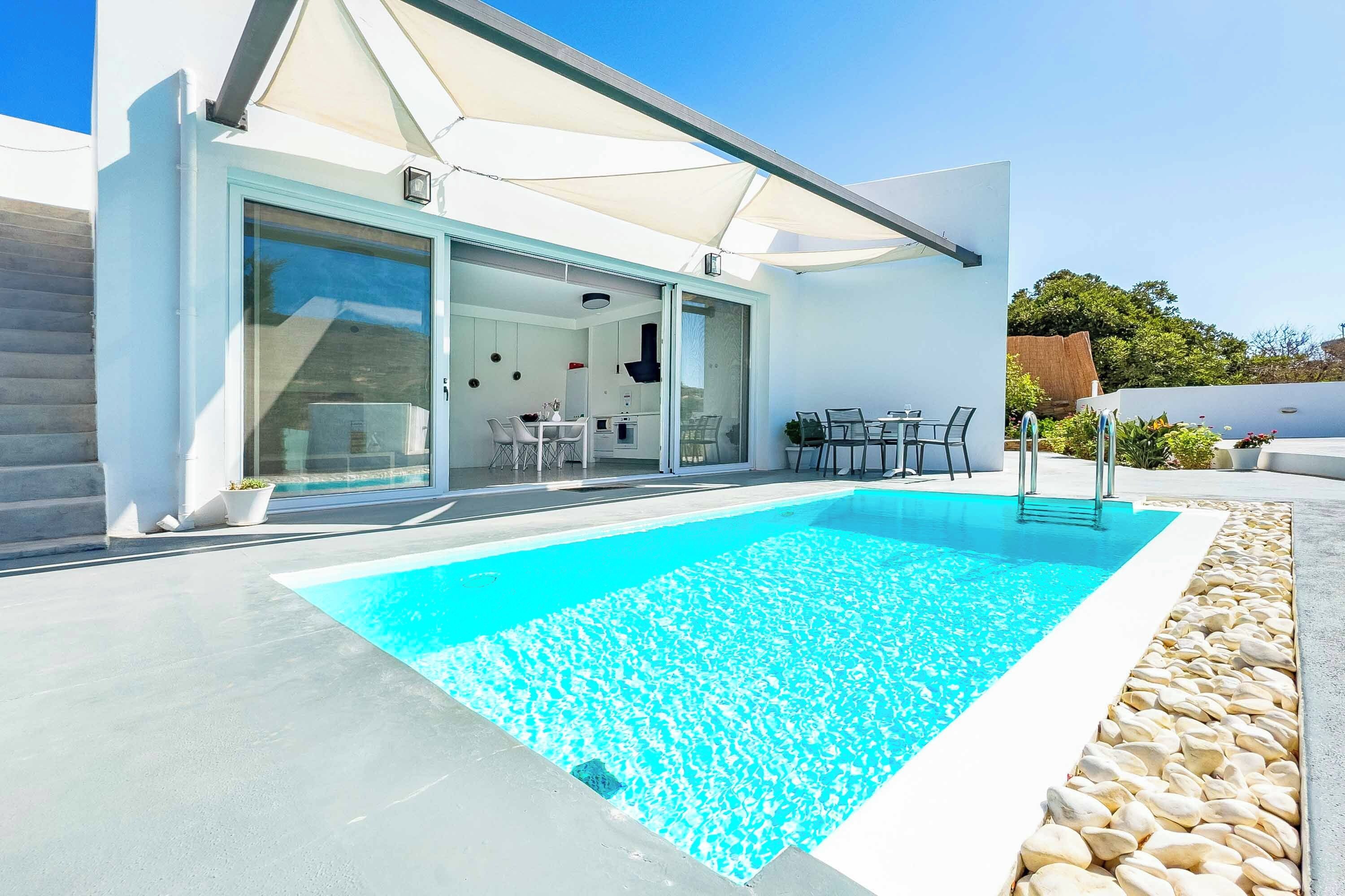 Una casa moderna con piscina, comedor y cocina.