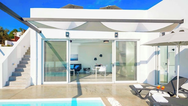 Eine moderne Villa mit Pool, Essbereich und einer Treppe zu den oberen Stockwerken.