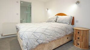 Een slaapkamer met een bed, nachtkastje en spiegel.
