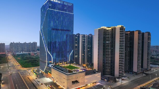 Un moderno edificio de gran altura con un diseño angular único, rodeado de otros edificios de gran altura.