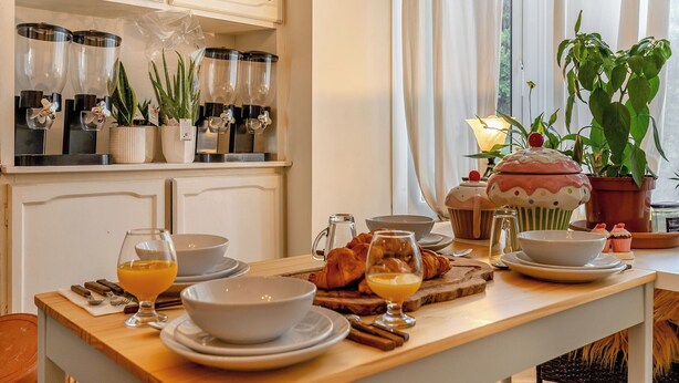 A breakfast table with various dishes, a coffee machine, and potted plants. - 3 bedroom accommodation in Buxton (Buxton)