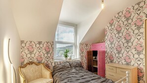 A bedroom with a bed, a chair, a dresser, and a window with blinds. - 3 bedroom accommodation in Buxton (Buxton)