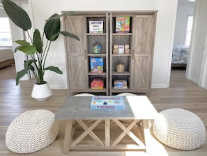 Relax in this inviting living room with a central table for board games and a bookshelf filled with a collection of games.