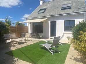 A modern house with a patio area featuring outdoor furniture and artificial grass. - House Sarzeau, 5pers. 50m from the beach of Penvins - 3*** furnished holiday home (Sarzeau)