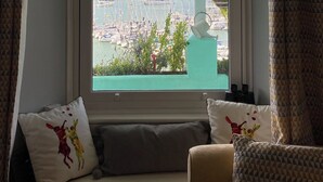 Blick aus einem Fenster mit einer Bank, Kissen und einer Glocke.