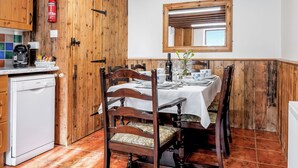 A wooden interior with a dining table set for four, a Bosch dishwasher, and a fire extinguisher. - Holly Lodge - UK36321 (Holly Hedge Farm)