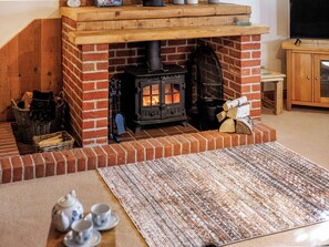 A cozy room with a brick fireplace, a television, and a wooden cabinet. - Holly Lodge - UK36321 (Holly Hedge Farm)