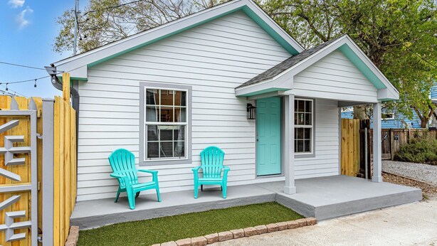 A white house with a green door, two turquoise Adirondack chairs, and a small front porch. - Private Uptown Cottage! Walk to Freret, Tulane & St. Charles Street Car (New Orleans)
