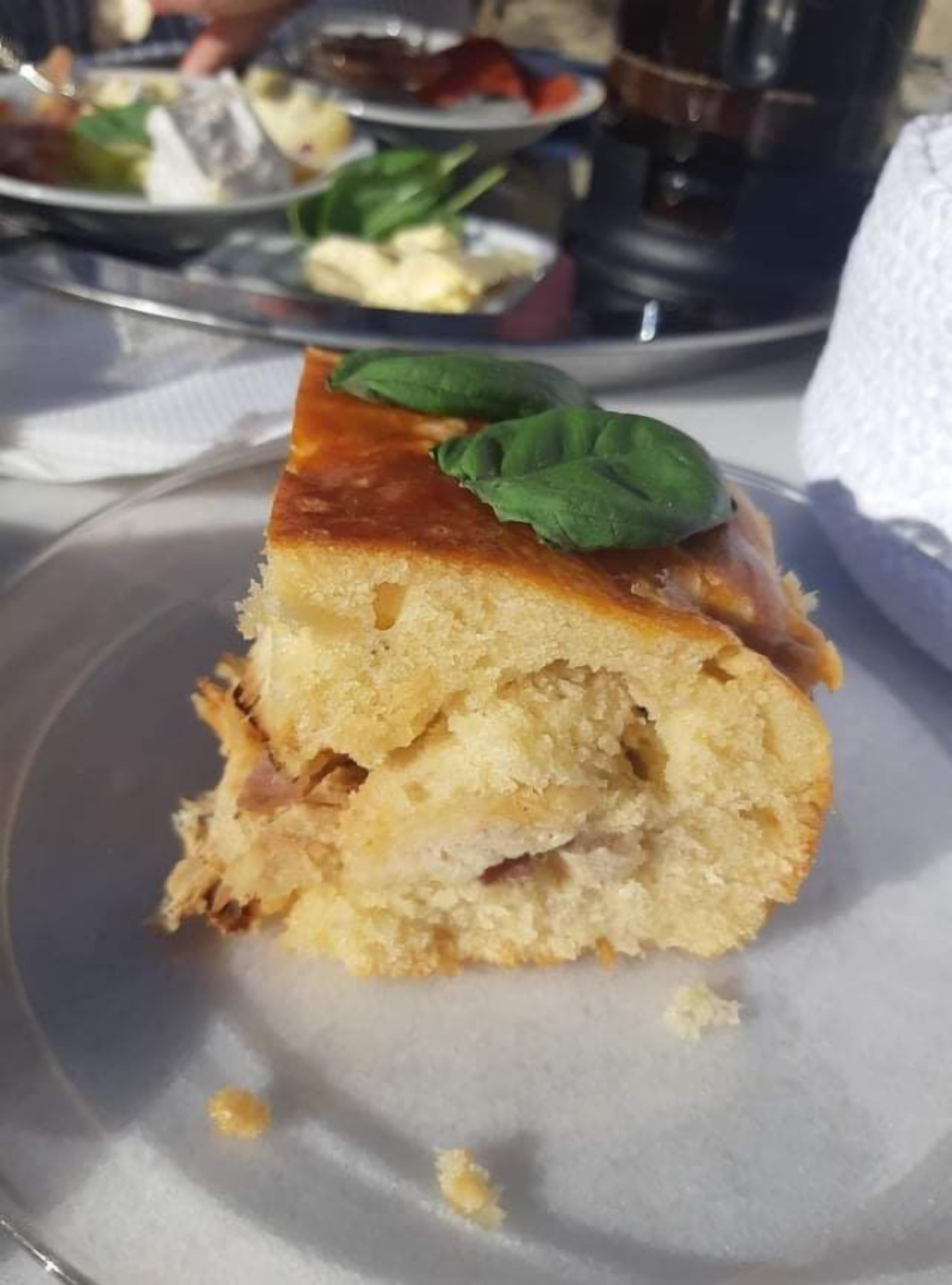 Una porción de pastel con una hoja verde decorativa en un plato.