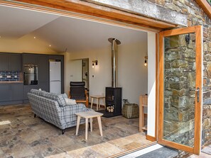 A cozy living area with a sofa, a small table, and a stone wall.