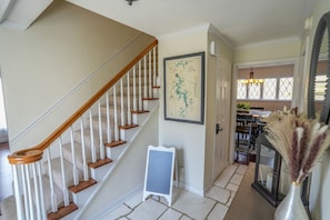 Staircase leads to an upper floor, with a framed map and a whiteboard-style sign nearby.