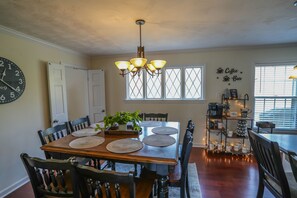 Enjoy meals in this dining area with a table for four, a chandelier, and a coffee bar.