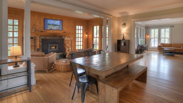 A spacious living area with a large wooden table, a fireplace, and a cozy seating arrangement. - Historic Home | Pet Friendly | Walkable to Downtown (Creede)