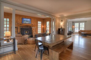 A spacious living area with a large wooden table, a fireplace, and a cozy seating arrangement. - Historic Home | Pet Friendly | Walkable to Downtown (Creede)