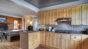 A kitchen with wooden cabinets, a gas stove, and a tiled backsplash. - Historic Home | Pet Friendly | Walkable to Downtown (Creede)
