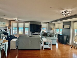 A spacious living room with a sofa, a dining table, and a TV.