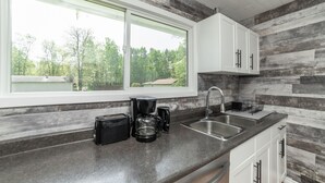 A kitchen with a large window, a sink, and a coffee maker. - 🏖 Sandy Hook: 2 Queens, Pet Friendly, One Min to Beach, Ice Fishing and Snaks (Sandy Hook)