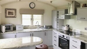Une cuisine dotée d’un plan de travail en marbre, d’un four encastré, d’un four à micro-ondes et d’un évier.