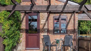 A brick building with a wooden door, two windows, and a sign reading "Purbek View". - Purbeck View - UK36320 (Holly Hedge Farm)