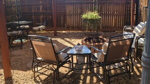 Un patio couvert agrémenté d’une pergola en bois, de guirlandes lumineuses et de mobilier d’extérieur.