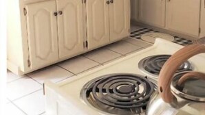 A kitchen with white cabinets, a stove, and a ceiling fan. - THE COZY COTTAGE, A Great place to hang your hat. (Post)