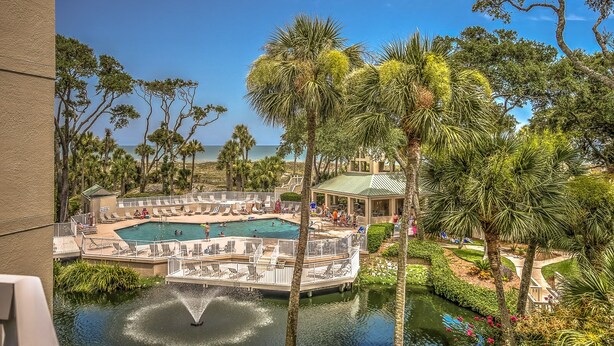 A pool area with multiple swimming pools, lounge chairs, and a gazebo. - 206 Barrington Arms- OCEANFRONT and BEAUTIFUL (Hilton Head Island)