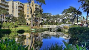 A residential area with a water feature, a bridge, and apartment buildings. - 206 Barrington Arms- OCEANFRONT and BEAUTIFUL (Hilton Head Island)