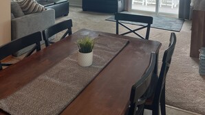 Ein Essbereich mit einer Pendelleuchte, einer Couch, einem Couchtisch und Blick ins Freie.