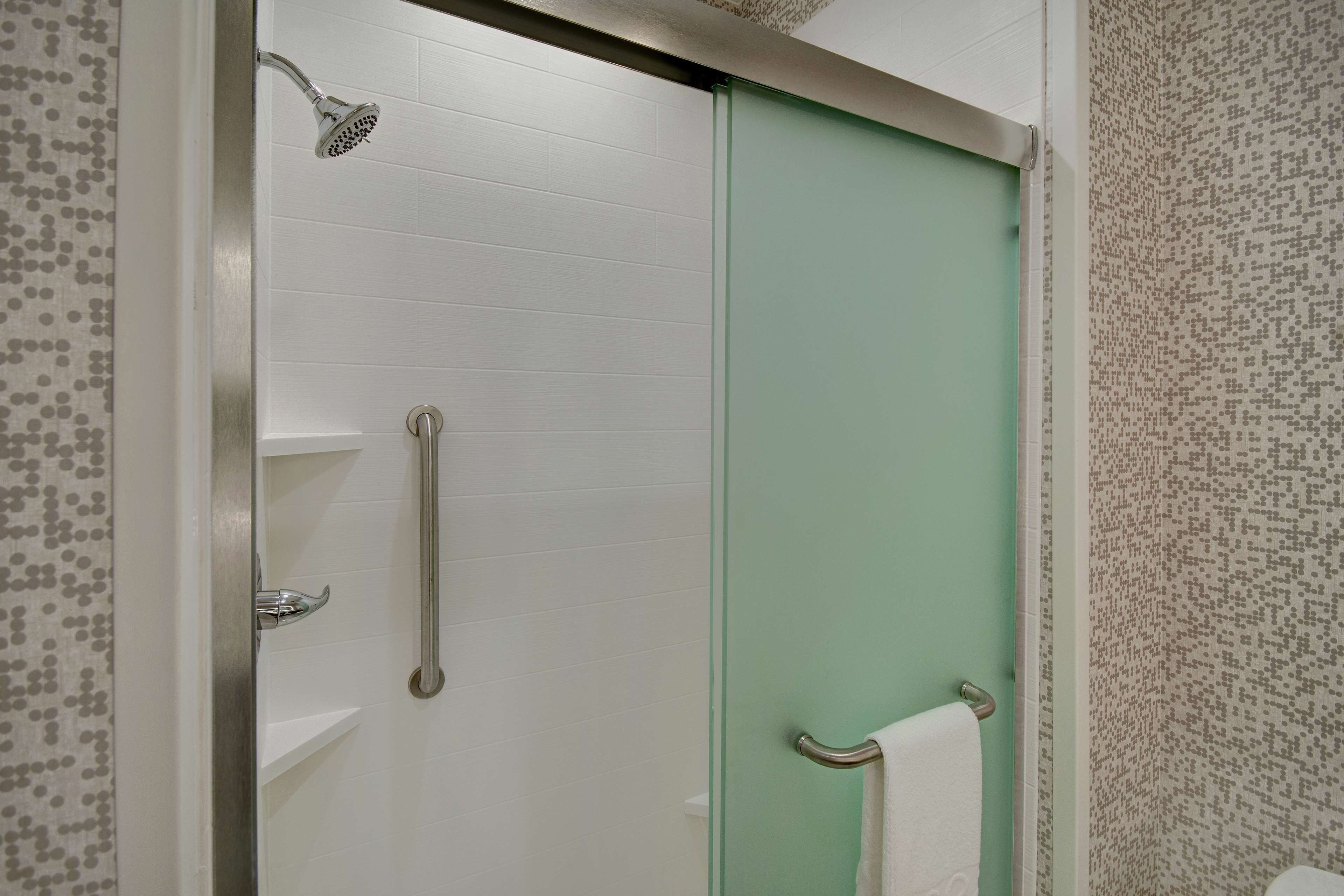 A bathroom with a shower, a toilet, and a sink.
