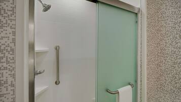 A bathroom with a shower, a toilet, and a sink.