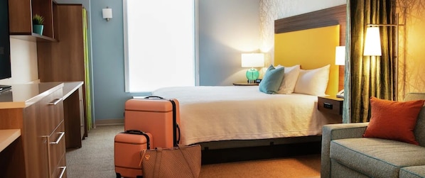 A hotel room with a bed, bedside lamps, a desk, and a chair. - Home2 Suites by Hilton Burleson (Burleson)