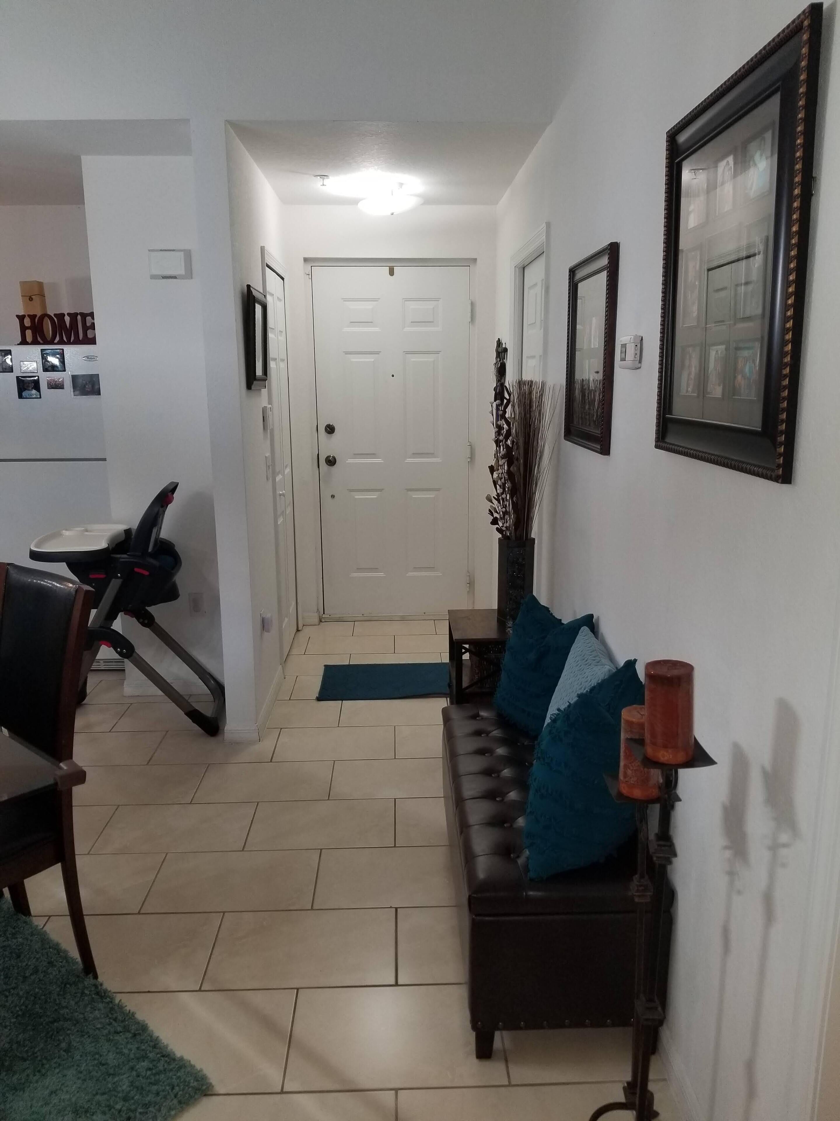 Ein Wohnzimmer mit einer Couch, einem Couchtisch und einem Laufband in der Ecke.