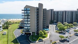 Un immeuble moderne à plusieurs étages, doté d’une allée incurvée et d’un parking.
