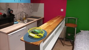 A compact kitchen with a sink, stove, and a wooden countertop. - Studio Welcome to Keylia (Saint-Étienne)