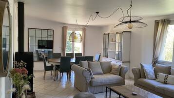 TV connectée, cheminée, table de tennis de table, livres