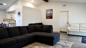 A modern living room with a sectional sofa, a smaller sofa, and a patterned rug. - Welcome to Oasis On The Links! (Paso Robles)