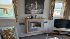 A living room with a fireplace, a television, a sofa, and a coffee table. - Remarkable 3-bed House in Hull (Hull)